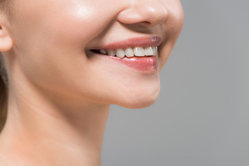 Obraz premium cropped view of cheerful woman smiling isolated on grey