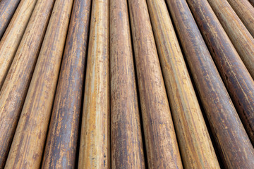 Rusty grunge pipes horizontal background. Orange corrosion rust on steel metal factory industrial pattern. Rough texture brown parallel stack close up