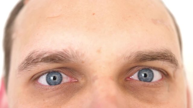 Close-up of a surprised emotional man with blue eyes looking into the camera. 3840x2160, 4k