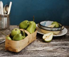 Green pears in a basket on the table