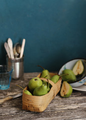 Green pears in a basket on the table