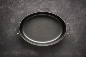 Empty Gray Nonstick Baking Dish with Handles on Dark Stone Surface. Culinary Background.