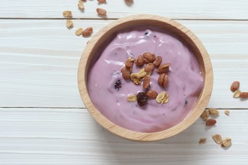 yogurt with very berry in wooden bowl on white background