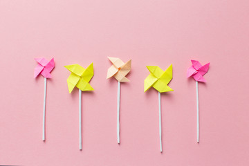 Windmills of paper on pink background, handmade, origami