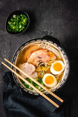 Japanese Ramen Soup with Udon Noodles, Pork, Eggs and Scallion on dark Stone Background - 267979698