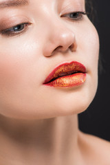 Fototapeta premium close up of attractive woman with orange lips isolated on black