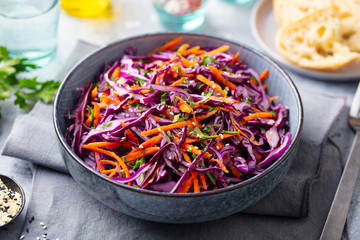 Red cabbage salad, Coleslaw in a bowl. Grey background. Close up.