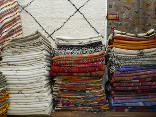 stacks of colorful folded carpets with bright ornaments.