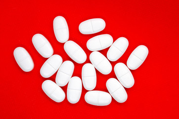 white pills on a red background