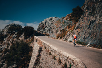 Biker on the road bicycle ride uphill on the famous Sa Calobra climb in Spain.