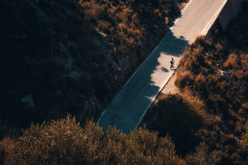 Biker silhouette on the road bicycle ride uphill on the famous Sa Calobra climb in Spain.
