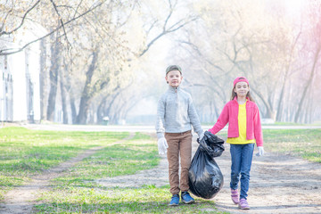 Kids carry a bag of trash. Ecology concept. Empty space for text