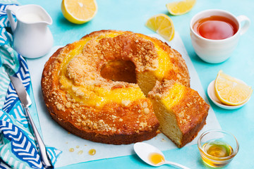Lemon bundt cake with cup of tea. Blue background. Close up.