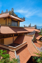 Tile red roof of asian temple with window on sunny day in Long Son Pagoda in Nha Trang