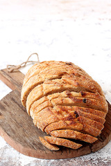 Freshly baked sliced bread on rustic wooden plate