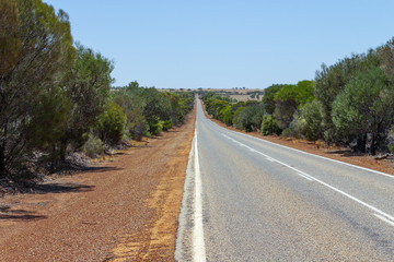 Fototapeta na wymiar Natural scenery on the open road in Australian Outback. Freedom and orange red road.