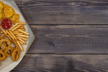 Assorted snacks  on dark wooden background. Empty space for text. Top view