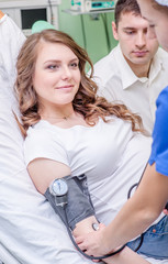 Fototapeta premium a nurse checks the health of a pregnant woman before giving birth in an operating room