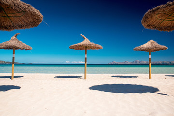Straw umbrellas on a tropical beach. Summer holiday concept photo