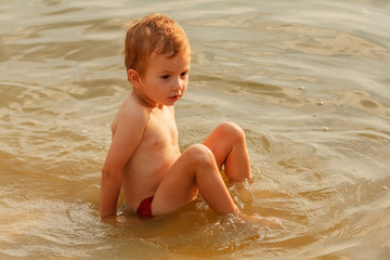 Little child swimming in river.