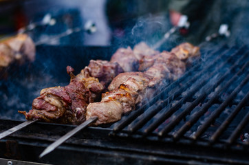 closeup of some meat skewers being grilled in a barbecue