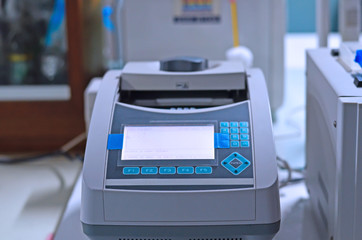 Scientist holding PCR tube put into PCR machine