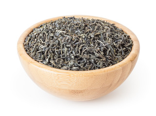 Dried green tea leaves in wooden bowl isolated on white background with clipping path