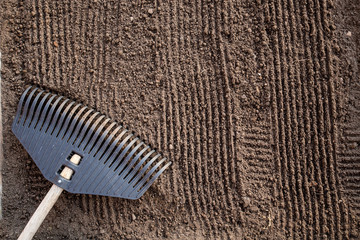 Preparation of land before planting. The texture of the soil with vertical grooves from the rake,...