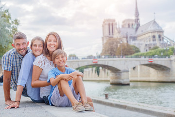 Happy family having fun near Notre-Dame cathedral in Paris. Tourists enjoying their vacation in France. - 267989471