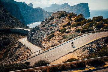 Triathlete men cycling road bike in the summer day. Beautiful nature in background. Mallorca,...