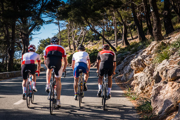 Group of triathletes on road bicycle, sport photo in nature. Majorca, Spain