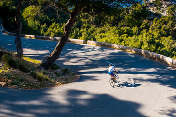 Triathlete men cycling road bike in the summer evening