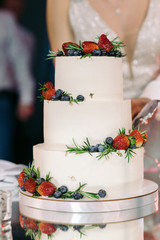 White wedding cake with fruit, strawberry and blueberries