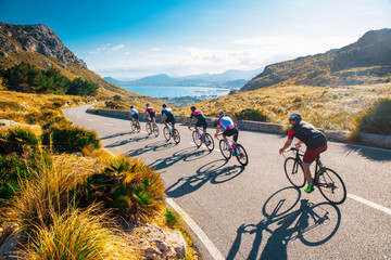 Team sport cyclist photo. Group of triathlete on bicycle ride on the road at Mallorca, Majorca, Spain. - obrazy, fototapety, plakaty