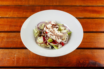 Mixed salad with feta on a wooden table