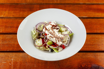 Mixed salad with feta on a wooden table