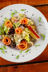 Salad with fresh salmon on a white plate close-up