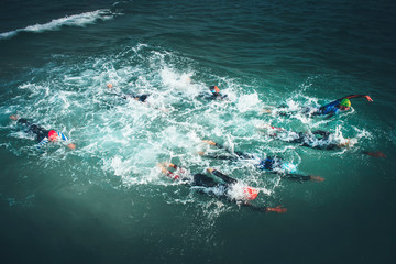 Professional swimmers swim during competition in the sea. Open water sport