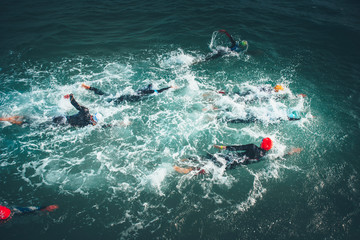 Triathlon swimmers churning up the water. Athletes practicing for triathletic race in lak