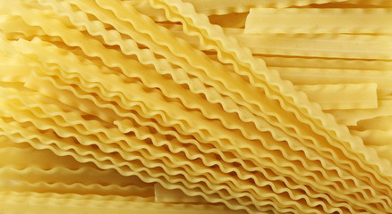 Uncooked Italian pasta mafaldine background and texture, top view