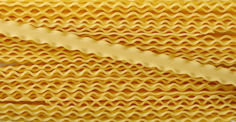 Uncooked Italian pasta mafaldine background and texture, top view