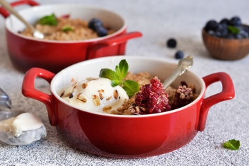 Berry crumble with nuts and ice cream on the kitchen table.