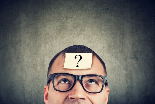 man in glasses with question mark looking up