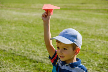 Boy playing with a toy red plane at park on a sunny day