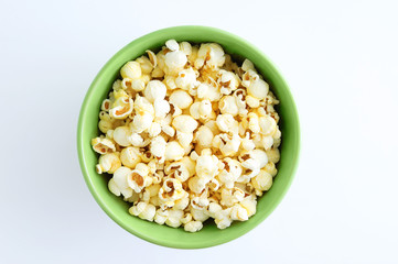 Fried popcorn in a green bowl. White background.