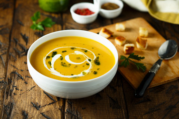 Homemade pumpkin soup with pesto sauce