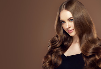 Beauty girl with long  and   shiny wavy hair .  Beautiful   woman model with curly hairstyle .