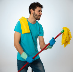 Young attractive proud man holding mop as microphone having fun while cleaning