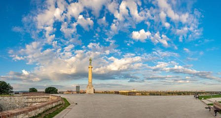Fototapeta premium Empty plateau on Kalemegdan with the monument of Victor overlooking the New Belgrade on a sunny spring morning with vivid clouds