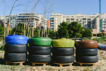 Wastebaskets to recycle paper, plastic and organic materials made with old recycled tires and painted colors, concept of sustainability and recycling.